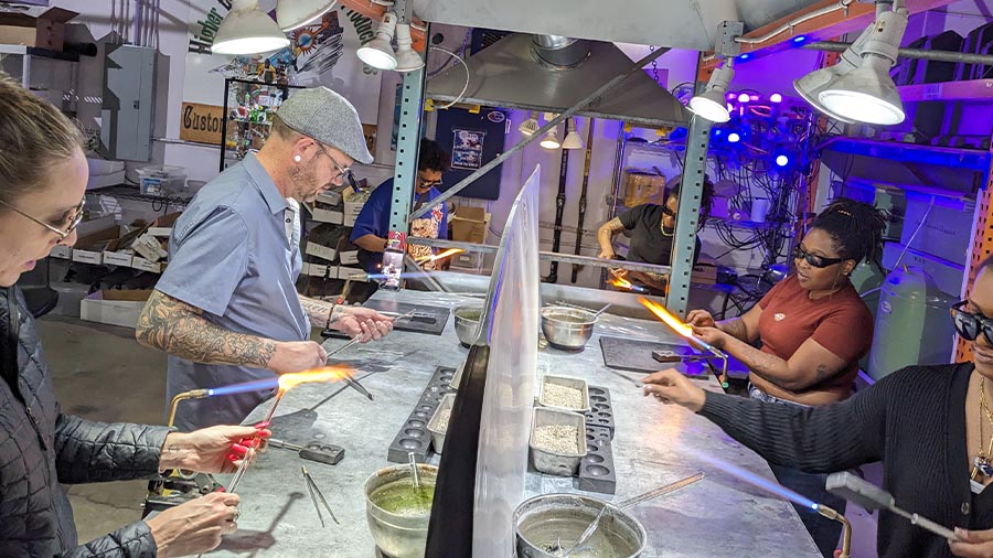 Student holding a finished glass piece from an Elev8 Arts glassblowing class